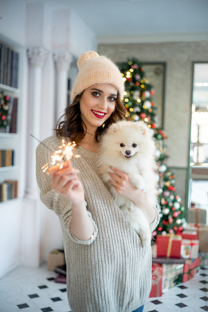 happy young woman is celebrating christmas at homeの写真素材