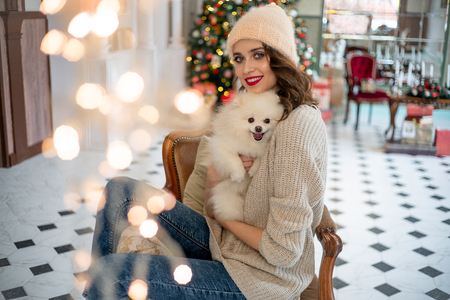happy young woman is celebrating christmas at homeの写真素材