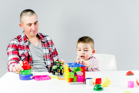 Dad and toddler son having fun playing at homeの写真素材