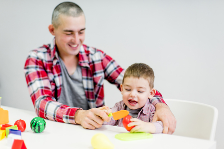 Dad and toddler son having fun playing at homeの写真素材