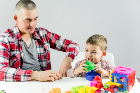 Dad and toddler son having fun playing at homeの写真素材