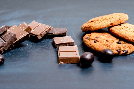 chocolate bar, shavings and cookies on a tableの写真素材