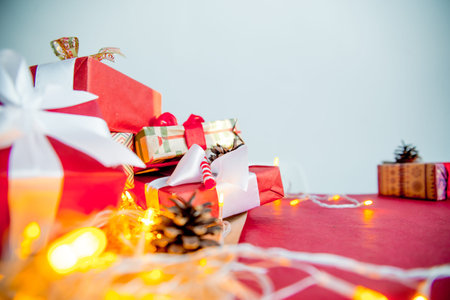Female hands wrapping red christmas gift boxesの写真素材