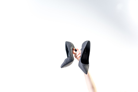Female hands holding fashionable high heel shoesの写真素材
