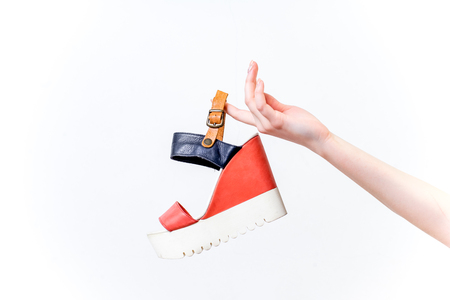 Female hands holding fashionable high heel shoesの写真素材