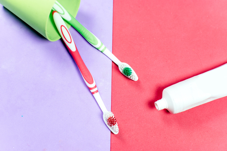 toothbrushes and a toothpaste on a colorful backgroundの写真素材