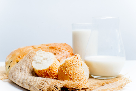 a glass of milk with bread and grainsの写真素材