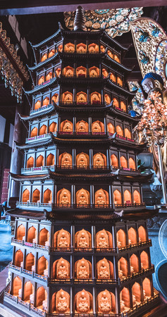Statue of pagoda with orange candles insideのeditorial素材