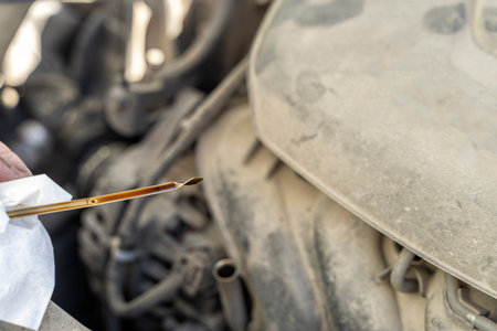 Auto mechanic works in the garage. Check engine oil level. oil dipstickの写真素材