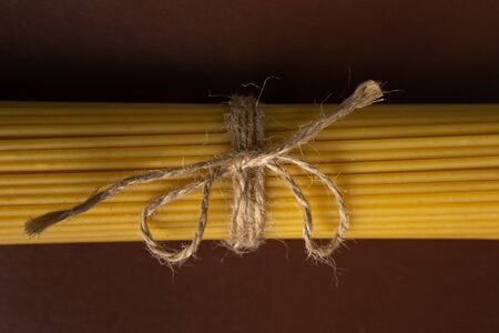 spaghetti on a brown background, tied with a rope,
Â copy spaceの写真素材
