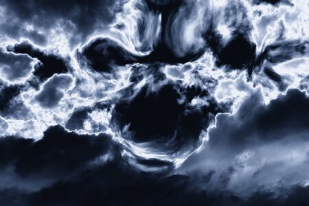 creepy scary face of black thunderclouds in a thunderous skyの写真素材