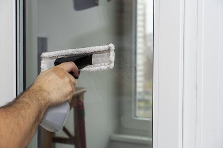a man washes a window in an apartment. House cleaningの写真素材