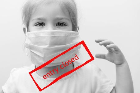 black and white portrait European child in medical mask with raised hand. red inscription in the frame "entry closed." closure of flights with European countries of the United Statesの写真素材