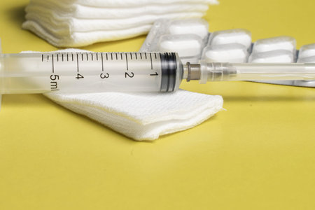 blister with pills and injection kit, syringe and sterile wipes on a yellow background. antiviral...