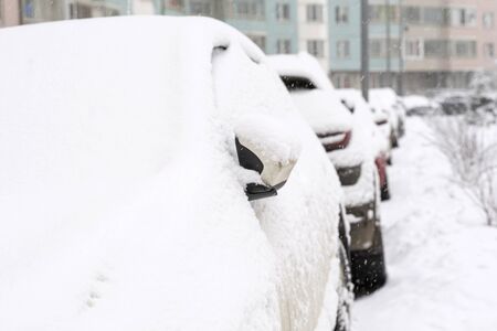 cars are parked in the yard covered with a thick layer of snowの写真素材