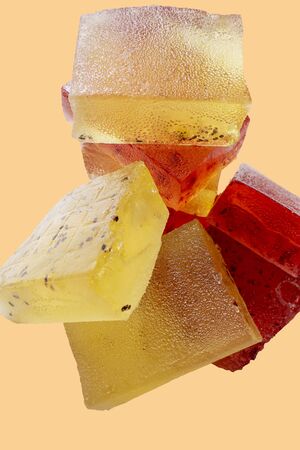 pieces of marmalade red and yellow on a light beige backgroundの写真素材