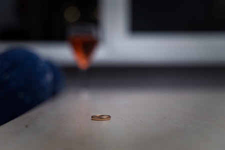 engagement ring lies on the table. in the background a glass of wine and a woman. topic of...