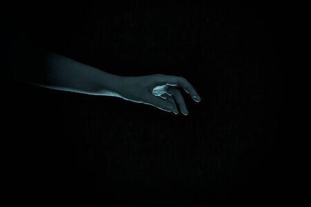 an ominous blue hand stretches out of the darkness. children's nightmares, fears, horror and ghostsの写真素材