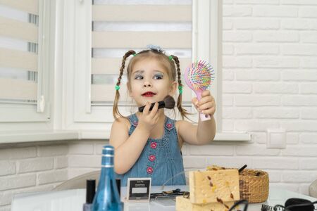 3-4 years old girl in a dressing dress is painted with mother s makeupの写真素材