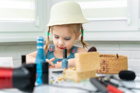 3-4 years old girl in a dressing dress is painted with mother s makeupの写真素材