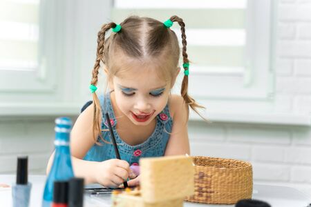 girl 4 years old funny makes makeup mom's makeup.の写真素材