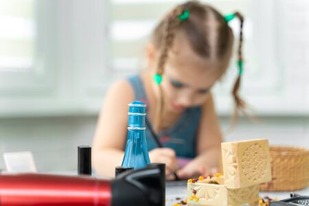 girl 4 years old makes makeup mom's makeup. focus on cosmetics, girl in blurの写真素材