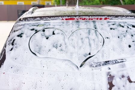 a heart is drawn on the car glass in foam at a car wash. symbol of respect for the car of the clientの写真素材