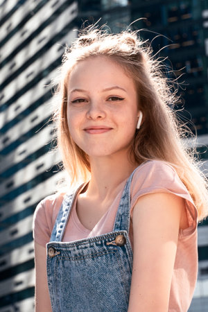 portrait of a beautiful young girl with an earpiece on the street
