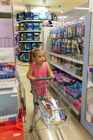 07 19 2020 Russia, Moscow, 07 19 2020 Russia, Moscow, Detsky Mir store.little girl with a shopping trolley makes purchases in a children's storeのeditorial素材