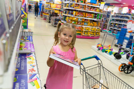 07 19 2020 Russia, Moscow, 07 19 2020 Russia, Moscow, Detsky Mir store.little girl with a shopping trolley makes purchases in a children's storeのeditorial素材