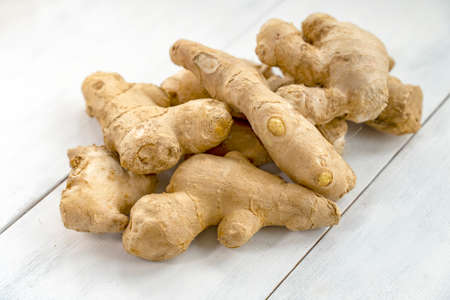 a bunch of ginger on a white wooden backgroundの写真素材
