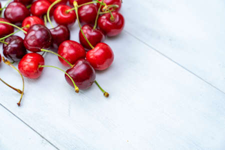 ripe juicy cherries on a white wooden background, selective focus. space for textの写真素材
