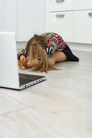 beautiful little girl with a bouquet of field daisies sits in the shade of a haystackの写真素材