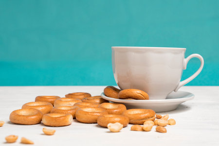 morning concept. a cup of tea with nuts and bagels. blue background, place for text