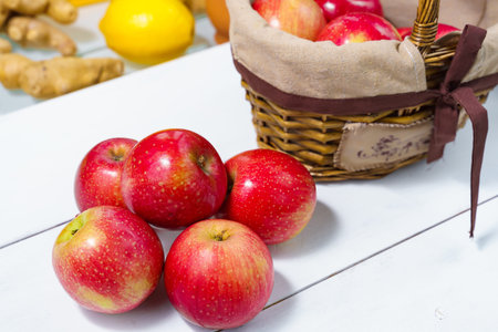 beautiful ripe appetizing red apples in a basket. four apples on the table