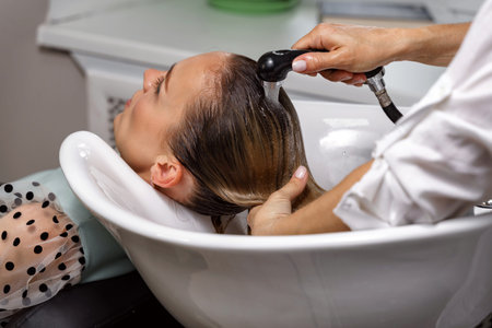 Beautiful woman getting hair wash in beauty salon. Concept head treatment care.
