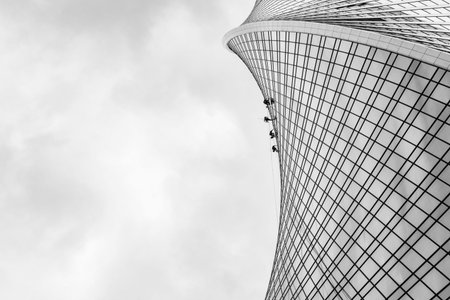 high-altitude window washers. work on the facade of the skyscraper. monochrome image
