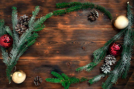 Christmas background with fir branches and decorations on old wooden table. Space for text or design. Top view.の写真素材