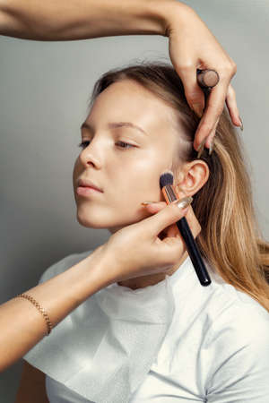 work of a makeup artist. young girl makeup processの写真素材