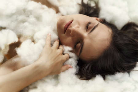 beautiful brunette woman sleeping in the cloudsの写真素材