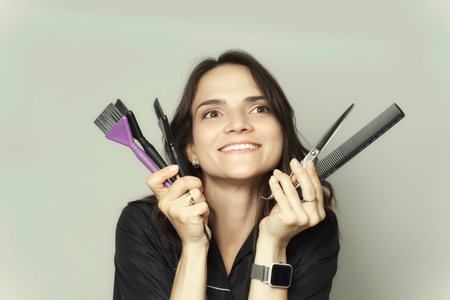 portrait of a beautiful young brunette woman with combs and scissors. hairdresser concept.