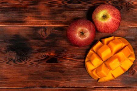 ripe mango and apples on a dark wooden background.の写真素材