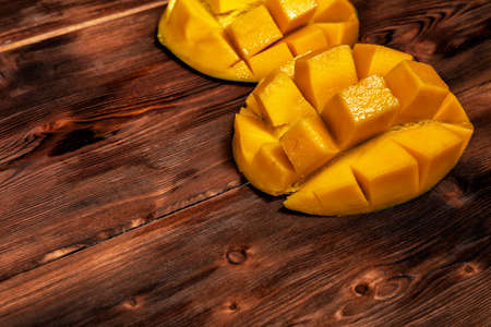 mango on a dark wood background. selective focus on the mangos slicesの写真素材