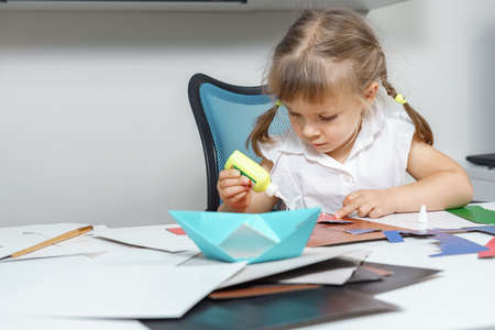 little girl is doing paper art with a teacherの写真素材