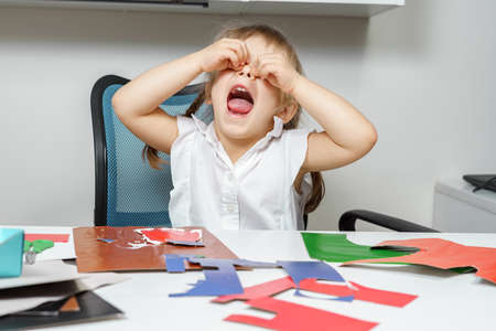 a little girl is crying because the paper craft does not work. childhood failuresの写真素材