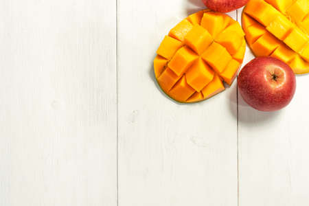 ripe mango and apples on white wooden backgroundの写真素材