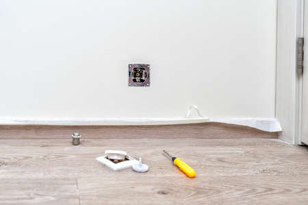 Removing the framing cover from the socket before painting. front cover and screwdriver are on the floorの写真素材