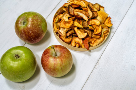 dried apples and fresh on a light wooden background