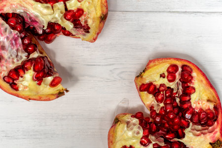 broken pomegranate fruit on a light wooden backgroundの写真素材
