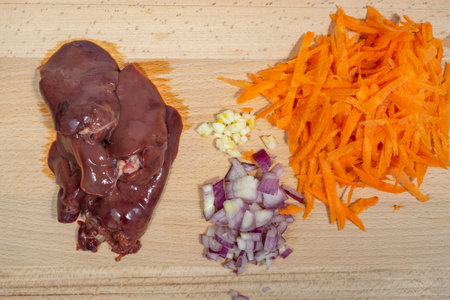 raw chicken liver and vegetables on a cutting wood boardの写真素材
